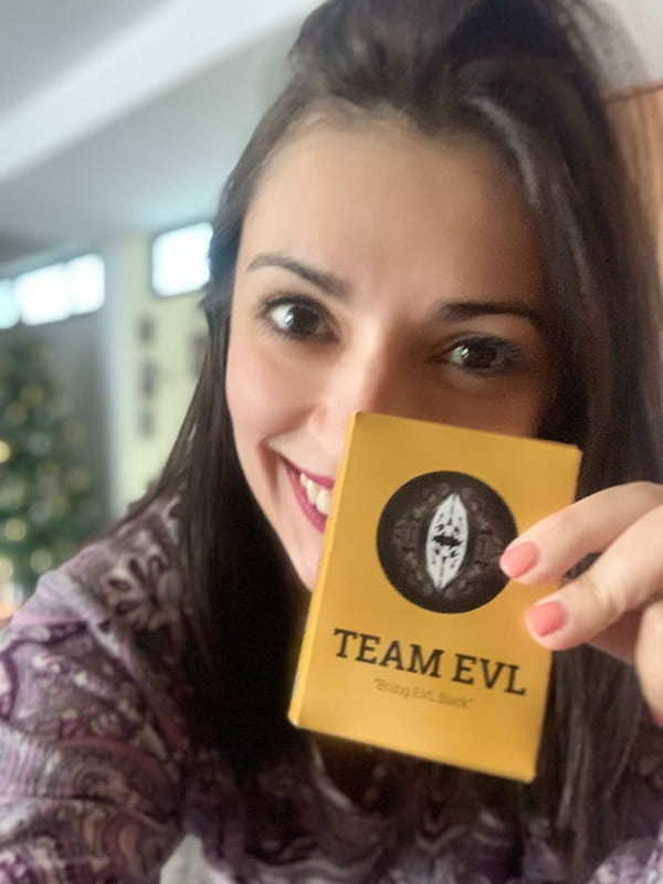 A player holding up the Team EvL box beside a Christmas tree
